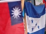 People hold national flags of Honduras and Taiwan during a gathering.