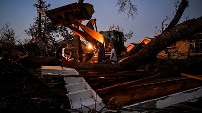 People cut down a fallen tree in the backyard of their house in Rolling Fork, Mississippi after a tornado touched down in the area. The powerful weather system, accompanied by thunderstorms and driving rain, cut a path of more than 100 miles (60 kilometers) across the state late March 24, slamming several towns along the way. (AFP) People cut down a fallen tree in the backyard of their house in Rolling Fork, Mississippi after a tornado touched down in the area. The powerful weather system, accompanied by thunderstorms and driving rain, cut a path of more than 100 miles (60 kilometers) across the state late March 24, slamming several towns along the way. (AFP)