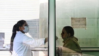 A health worker collects a swab sample for Covid-19 test in Noida. (Sunil Ghosh/HT Photo)