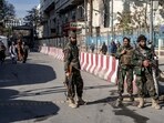 Taliban fighters stand guard at the explosion site, near the Foreign Ministry in Kabul.