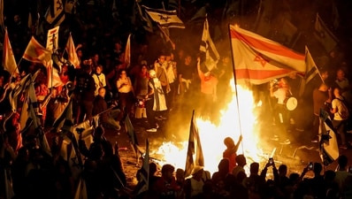 Fire burns as people attend a demonstration after Israeli Prime Minister Benjamin Netanyahu dismissed the defense minister. (Reuters) Fire burns as people attend a demonstration after Israeli Prime Minister Benjamin Netanyahu dismissed the defense minister. (Reuters)