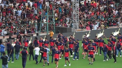 Former RCB players Chris Gayle and AB De Villiers with current team members acknowledge the crowd during RCB Unbox event at Chinnaswamy Stadium in Bengaluru (PTI) Former RCB players Chris Gayle and AB De Villiers with current team members acknowledge the crowd during RCB Unbox event at Chinnaswamy Stadium in Bengaluru (PTI)