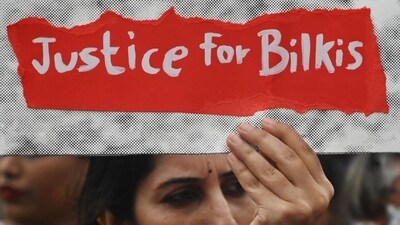 A woman holds a placard during a protest against the release of men convicted of gang-raping Bilkis Bano during the 2002 communal riots in Gujarat, in Mumbai. (AFP file) A woman holds a placard during a protest against the release of men convicted of gang-raping Bilkis Bano during the 2002 communal riots in Gujarat, in Mumbai. (AFP file)