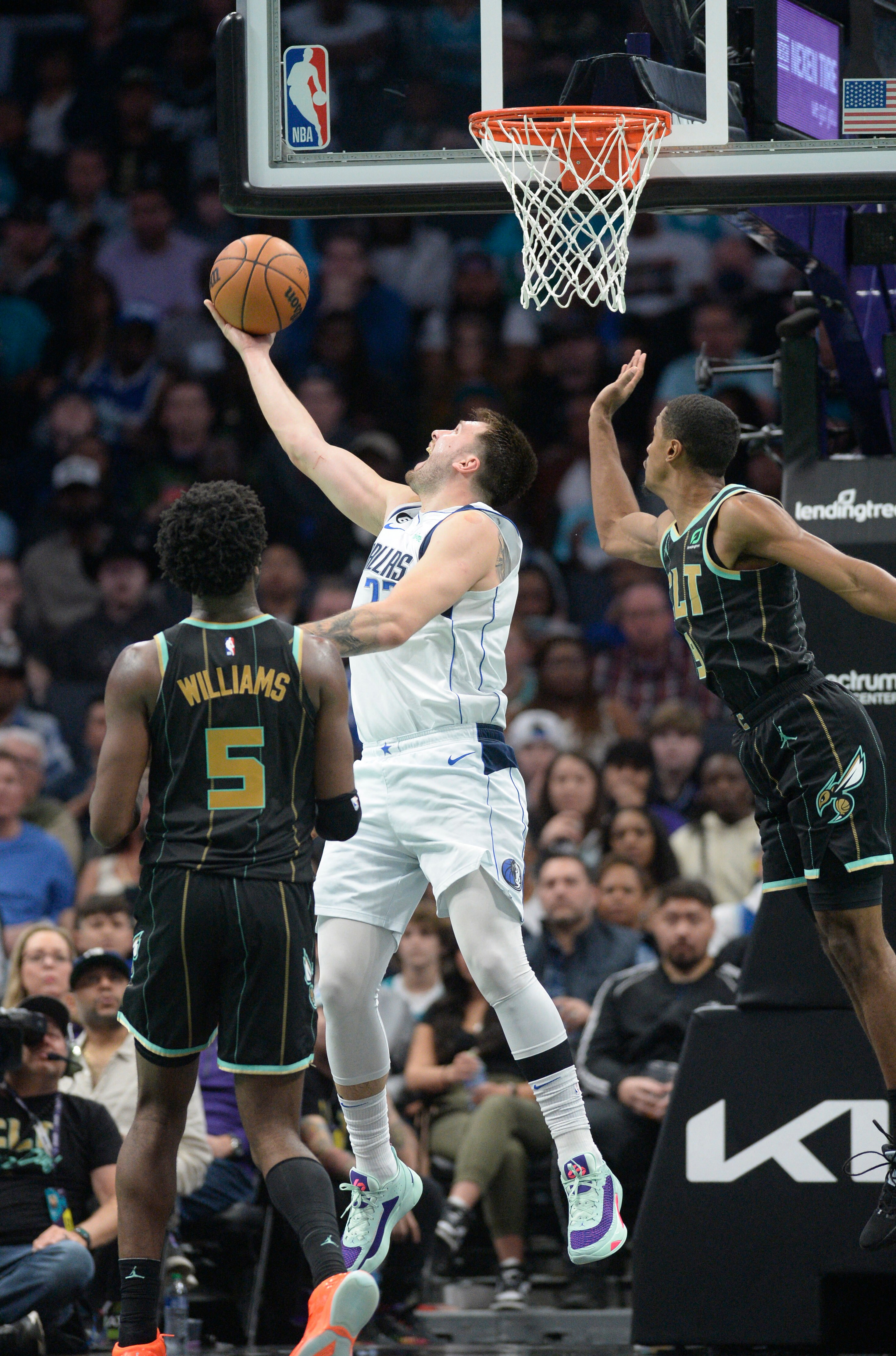 Dallas Mavericks guard Luka Doncic (77) drives in past Charlotte Hornets guard Theo Maledon (9) for a reverse lay-up during the second half at the Spectrum Center. (USA TODAY Sports)