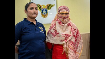 A Crime Branch officer with Malini Patel, wife of conman Kiran Patel, in Ahmedabad on Tuesday. (PTI) A Crime Branch officer with Malini Patel, wife of conman Kiran Patel, in Ahmedabad on Tuesday. (PTI)
