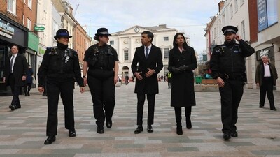 Britain's Prime Minister Rishi Sunak (C) and Britain's Home Secretary Suella Braverman (2ndR) walk with Community Support Officer Sonja Viner (L), Police Sergeant Sophie Chesters (2ndL) and Police Sergeant Matt Collins during a visit to Chelmsford in the county of Essex, east of England. (AFP)