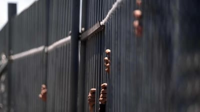Migrants hold the fence bars of the immigration detention center where 38 migrants died during a fire in Ciudad Juarez, Chihuahua state, Mexico on Wednesday. (AFP) Migrants hold the fence bars of the immigration detention center where 38 migrants died during a fire in Ciudad Juarez, Chihuahua state, Mexico on Wednesday. (AFP)