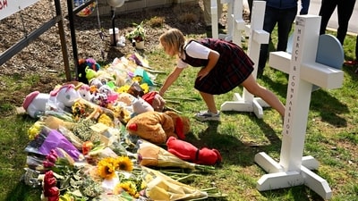 A young girl places an item at a growing memorial in Nashville, at an entry to Covenant School for the victims of Monday' shooting. (AP) A young girl places an item at a growing memorial in Nashville, at an entry to Covenant School for the victims of Monday' shooting. (AP)
