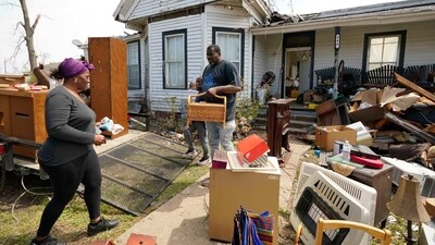 Family members of Silver City, Miss., resident Mary Kitchen, carry out salvageable items from her home, Tuesday. (AP)