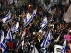 Protesters block a road and hold national flags during a rally against the Israeli government's judicial reform in Tel Aviv, Israel on March 27, 2023. (Photo by AHMAD GHARABLI / AFP)