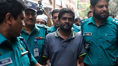 Shamsuzzaman Shams: Police escort reporter Shamsuzzaman Shams (C), who has been arrested and charged under the Digital Security Act. (AFP) Shamsuzzaman Shams: Police escort reporter Shamsuzzaman Shams (C), who has been arrested and charged under the Digital Security Act. (AFP)
