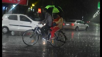 Commuters caught in rain in Chandigarh on Thursday evening. (Keshav Singh/HT)