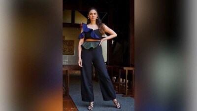 Aditi Rao Hydari's striking jumpsuit is a combination of black and blue, with eye-catching ruffled sleeves, a sweetheart neckline, and a vibrant orange belt around the waist. The outfit is completed with wide-leg pants, making Aditi look effortlessly elegant. (Instagram/@sanamratansi) Aditi Rao Hydari's striking jumpsuit is a combination of black and blue, with eye-catching ruffled sleeves, a sweetheart neckline, and a vibrant orange belt around the waist. The outfit is completed with wide-leg pants, making Aditi look effortlessly elegant. (Instagram/@sanamratansi)