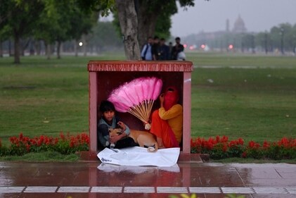 The image shows a kid sheltering his dog from the rain in Delhi. (HT Photo/Vipin Kumar) The image shows a kid sheltering his dog from the rain in Delhi. (HT Photo/Vipin Kumar)