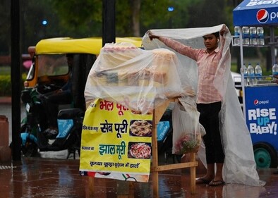A street vendor sheltering himself from the rain in Delhi. (HT Photo/Vipin Kumar) A street vendor sheltering himself from the rain in Delhi. (HT Photo/Vipin Kumar)