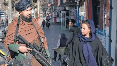 Taliban In Afghanistan: A Taliban fighter stands guard as a woman walks past in Kabul, Afghanistan. (AP) Taliban In Afghanistan: A Taliban fighter stands guard as a woman walks past in Kabul, Afghanistan. (AP)