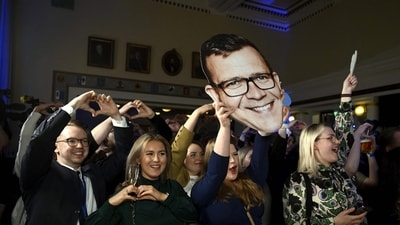 Supporters of the liberal-conservative National Coalition Party cheer during the party's parliamentary election party in Helsinki. (AFP)