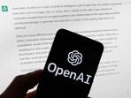 The OpenAI logo is seen on a mobile phone in front of a computer screen displaying output from ChatGPT. The OpenAI logo is seen on a mobile phone in front of a computer screen displaying output from ChatGPT.