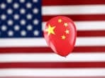 China Spy Balloon: A printed balloon with Chinese flag is placed on a US flag in this illustration.