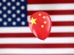 China Spy Balloon: A printed balloon with Chinese flag is placed on a US flag in this illustration.
