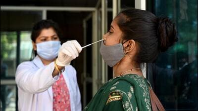 A health worker collects a swab sample at the District Hospital in Sector 30 in Noida on Monday. (Sunil Ghosh/HT Photo) A health worker collects a swab sample at the District Hospital in Sector 30 in Noida on Monday. (Sunil Ghosh/HT Photo)
