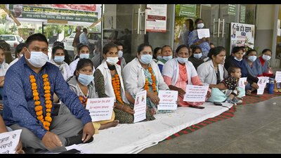 Ludhiana Civil Hospital contractual employees staging a protest in Ludhiana on Monday. (Gurpreet Singh/HT Photo)