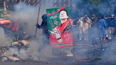 Supporters of former Prime Minister Imran Khan take cover after riot police officers fire tear gas to disperse them during clashes, in Lahore, Pakistan, Wednesday, March 15, 2023. (AP) Supporters of former Prime Minister Imran Khan take cover after riot police officers fire tear gas to disperse them during clashes, in Lahore, Pakistan, Wednesday, March 15, 2023. (AP)