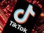 A smartphone with a displayed TikTok logo is placed on a computer motherboard.