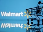 Shopping trolley is seen in front of Walmart logo.