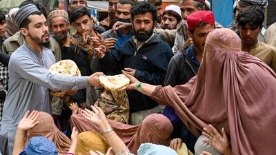 Burqa-clad women wait for free bread at a distribution point in Peshawar on April 3. (AFP) Burqa-clad women wait for free bread at a distribution point in Peshawar on April 3. (AFP)