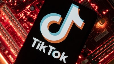 A smartphone with a displayed TikTok logo is placed on a computer motherboard. (REUTERS)