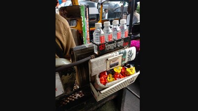 The image shows a Mumbai auto driver providing free water bottle, biscuits to passengers. (Twitter/@123_nandini)