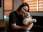 Herminhilda del Rosario poses for a picture with a realistic pet plushie of her departed dog Luna