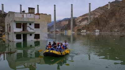 Volunteers from an animal rights NGO Haytap, paddle a dinghy as they search for stray cats and dogs to rescue in the town of Yusufeli. Rising water from an artificial lake caused by the dam has led to flooding and several relocations for the residents. (Yasin Akgul / AFP) Volunteers from an animal rights NGO Haytap, paddle a dinghy as they search for stray cats and dogs to rescue in the town of Yusufeli. Rising water from an artificial lake caused by the dam has led to flooding and several relocations for the residents. (Yasin Akgul / AFP)