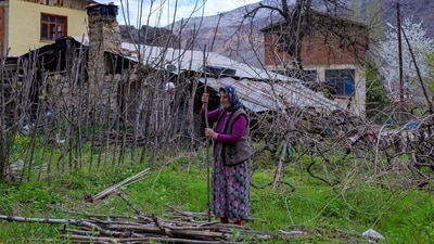 A woman is seen preparing a bundle of wood in the village of Tekkale, which will soon be submerged by the artificial lake, on April 5, 2022. (Yasin Akgul / AFP) A woman is seen preparing a bundle of wood in the village of Tekkale, which will soon be submerged by the artificial lake, on April 5, 2022. (Yasin Akgul / AFP)