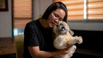 Herminhilda del Rosario poses for a picture with a realistic pet plushie of her departed dog Luna (REUTERS)