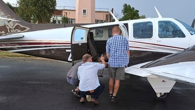 In this photo provided by Brian Emmenis, people look inside a plane at the Welkom Airport, in Welkom, South Africa, as they search for a venomous snake that the pilot found hiding under his seat midair, Monday April 3, 2023. (AP) In this photo provided by Brian Emmenis, people look inside a plane at the Welkom Airport, in Welkom, South Africa, as they search for a venomous snake that the pilot found hiding under his seat midair, Monday April 3, 2023. (AP)
