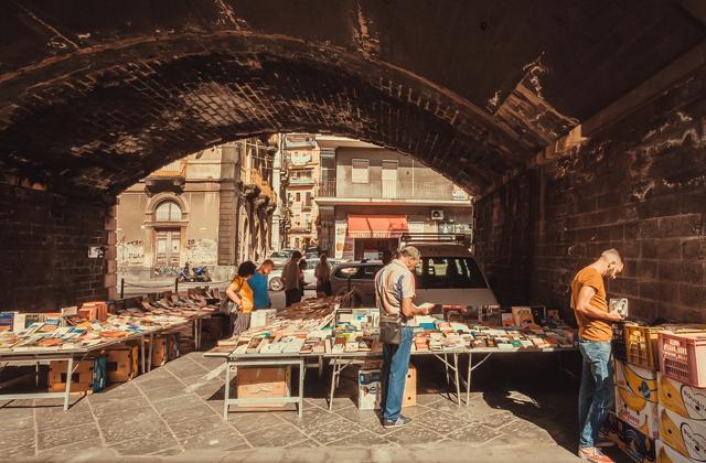People reading old books at the antique market under the city bridge in Catania, Italy. (Radiokafka/Shutterstock) People reading old books at the antique market under the city bridge in Catania, Italy. (Radiokafka/Shutterstock)