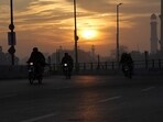Pakistan Economic Crisis: People ride a motorbike at sunrise in the city of Karachi.(AP)