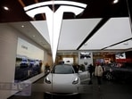 Visitors check a Tesla Model 3 car next to a Model Y displayed at a showroom of the U.S. electric vehicle (EV) maker in Beijing, China February 4, 2023. REUTERS/Florence Lo