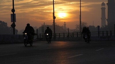 Pakistan Economic Crisis: People ride a motorbike at sunrise in the city of Karachi.(AP) Pakistan Economic Crisis: People ride a motorbike at sunrise in the city of Karachi.(AP)