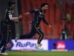 Gujarat Titans' Rashid Khan (R) celebrates after taking the wicket of Kolkata Knight Riders' Shardul Thakur 