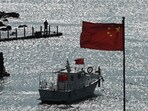 A man stands on a jetty behind a tourist boat and Chinese flags on Pingtan island, opposite Taiwan, in China�s southeast Fujian province on Sunday. A man stands on a jetty behind a tourist boat and Chinese flags on Pingtan island, opposite Taiwan, in China�s southeast Fujian province on Sunday.