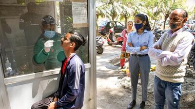 A healthcare worker collects a swab sample of a man for Covid-19 test. (PTI)