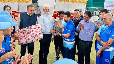 Hindustan Times Executive Editor Ramesh Vinayak, flanked by UTCA chief Sanjay Tandon, hands over the winning trophy to the Press Club team member after the exhibition match at the Sector 16 stadium. (HT Photo)