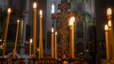 Lit candles are placed during the Palm Sunday Mass at the Orthodox Church of the Holy Spirit in Vilnius, Lithuania. (AP)