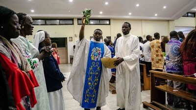 A priest blesses the congregation at the Our Lady of the Angels Church during the Easter Vigil celebrations in Dakar, Senegal. (AFP)