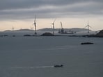 A fishing boat sails past wind turbines north of Pingtan island, opposite Taiwan, in China.