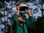 Spain's Jon Rahm celebrates with his green jacket and the trophy after winning The Masters.