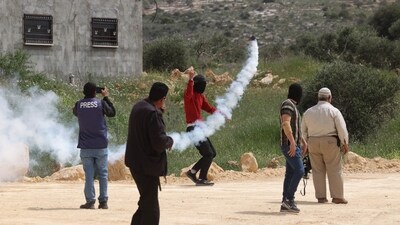 A Palestinian protester hurls a teargas canister back at Israeli soldiers during a protest in the village of Beita situated in the south of Nablus in the occupied West Bank, on April 10 against a march by settlers to the nearby Israeli outpost of Eviatar. (Jaafar Ashtiyeh / AFP) A Palestinian protester hurls a teargas canister back at Israeli soldiers during a protest in the village of Beita situated in the south of Nablus in the occupied West Bank, on April 10 against a march by settlers to the nearby Israeli outpost of Eviatar. (Jaafar Ashtiyeh / AFP)
